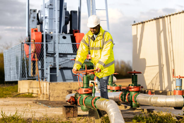 Oil field worker checking pipeline pressure of an oil rig.